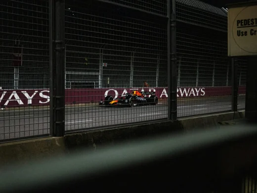 Formel 1-bil på upplyst bana under ett kvällslopp