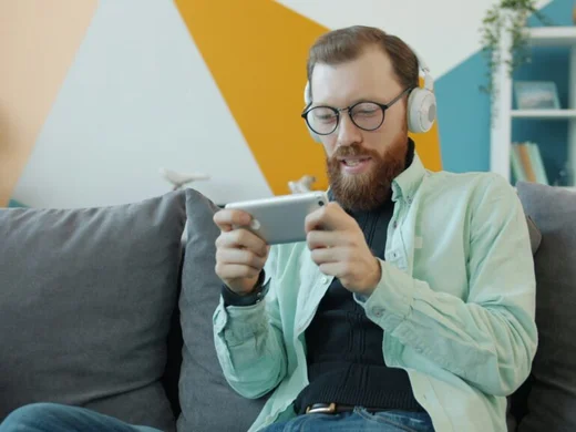 Man följer matchstatistik i mobilen hemma i soffan