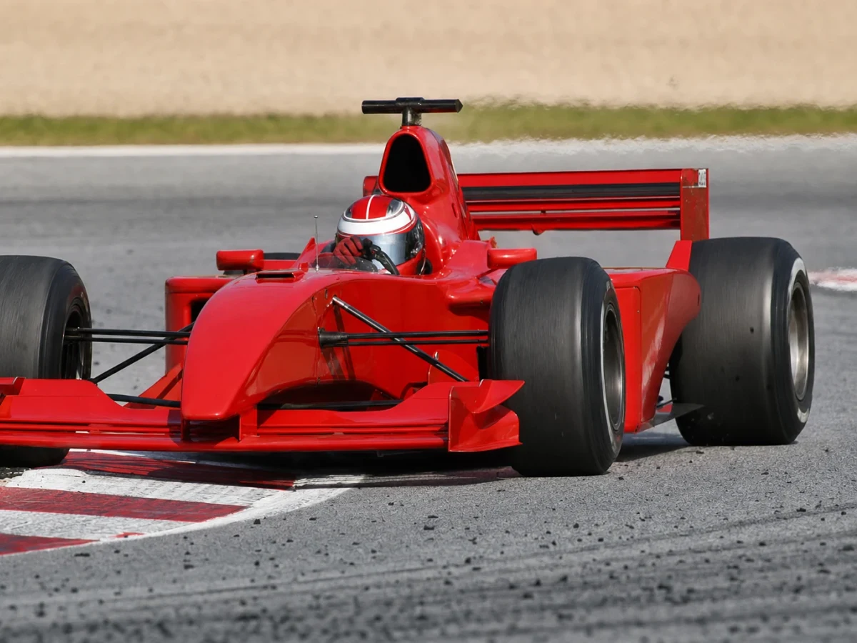 Illustration: en röd Formel 1-bil från Ferrari på banan i mitten av 2000-talet.