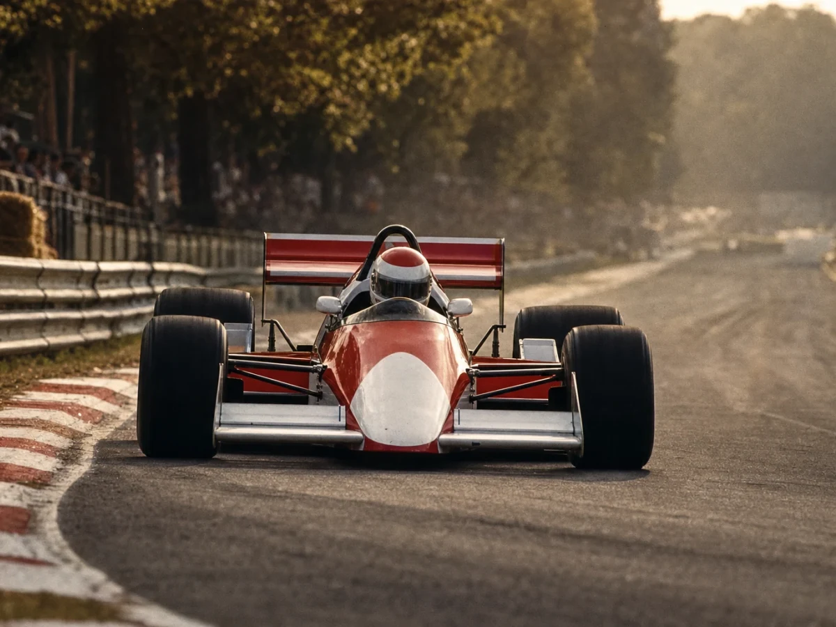 Illustration: en röd och vit Formel 1-bil från slutet av 1980-talet på banan.