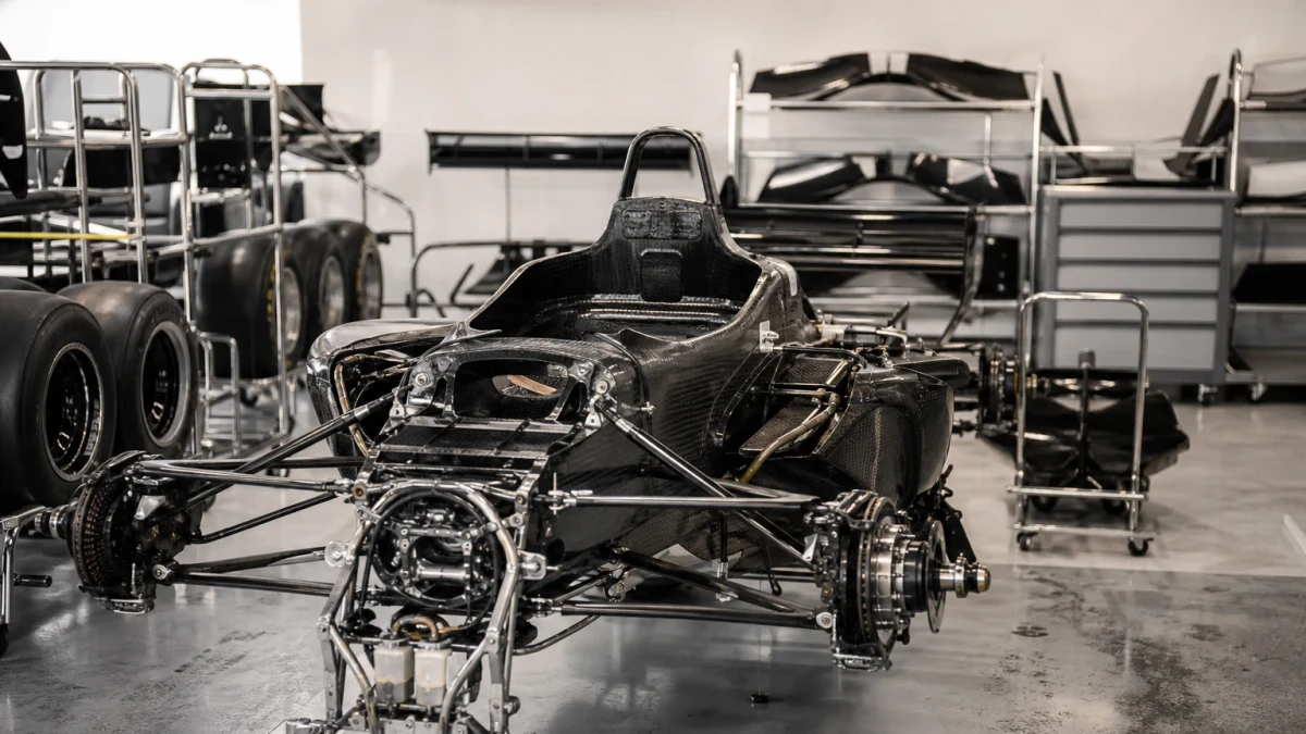 Illustration: f1-bil i depåmiljö som illustrerar kostnaden för en Formel 1-bil