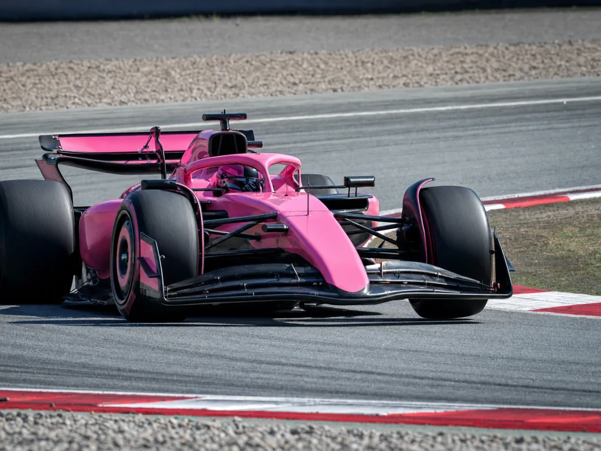 Illustration: en rosafärgad Formel 1-bil på banan under en träning.
