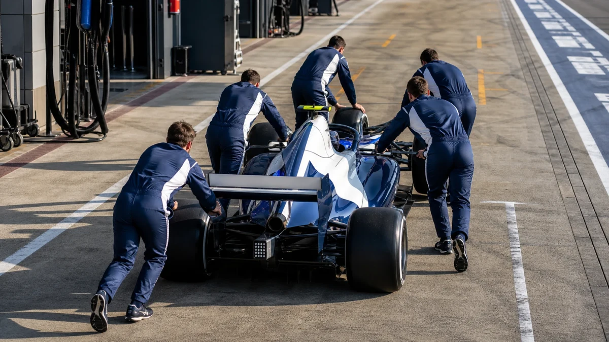 Illustration: en blåfärgad F1-bil på banan under en träning