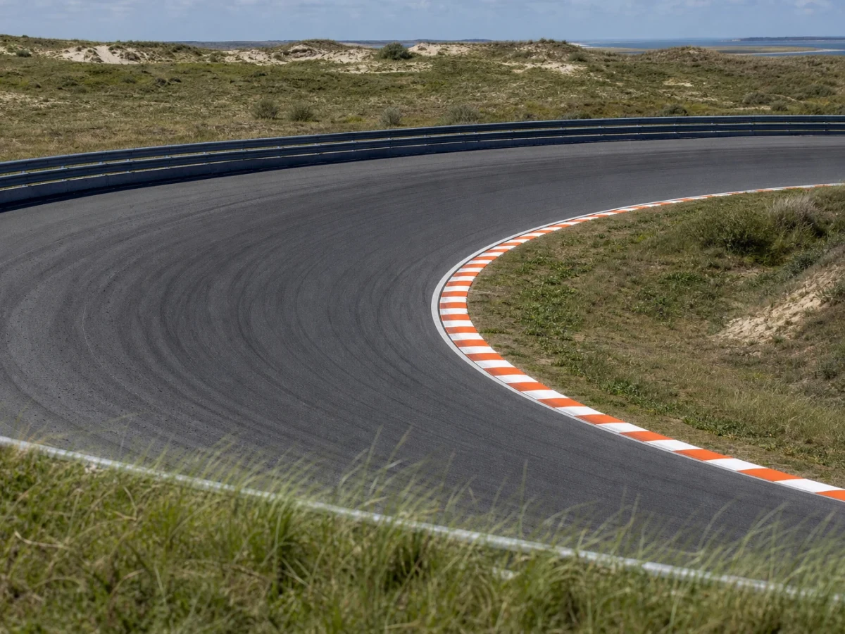 Illustration: formel 1-bana med doserad kurva omgiven av sanddyner